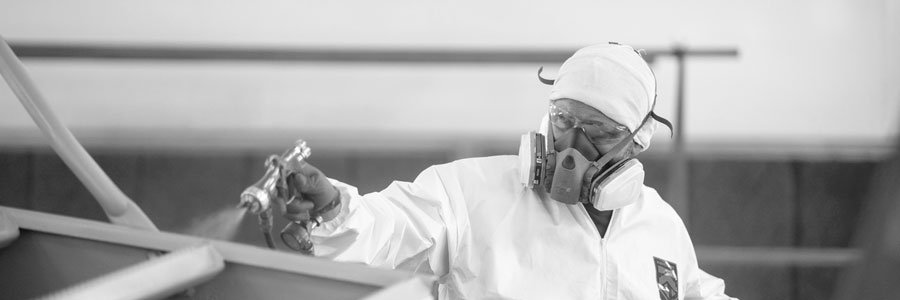 Bulk Equipment Employee Wearing Safety Gear While Painting Equipment For A Rebuild